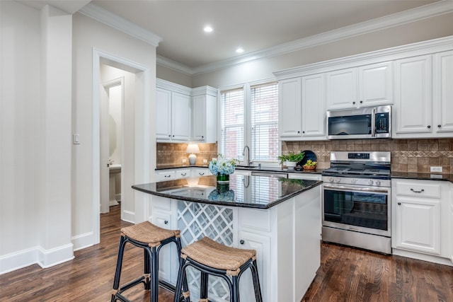 kitchen featuring dark wood-style flooring, stainless steel appliances, and white cabinetry