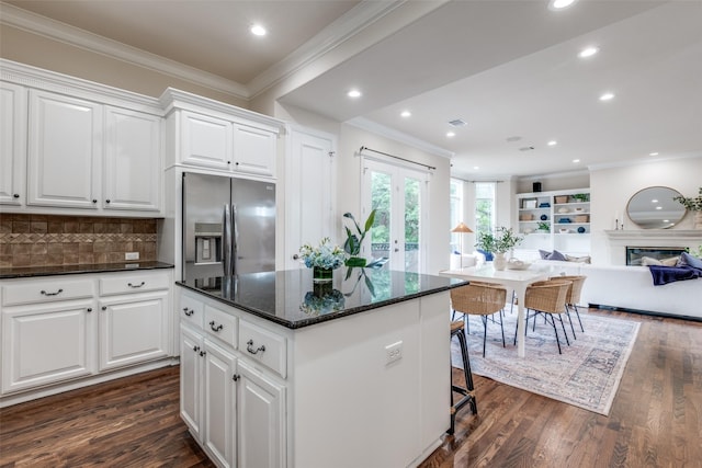 kitchen with stainless steel fridge with ice dispenser, open floor plan, dark wood-type flooring, a kitchen island, and ornamental molding