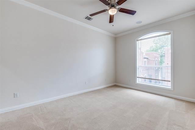 empty room with light colored carpet, ceiling fan, visible vents, and a wealth of natural light