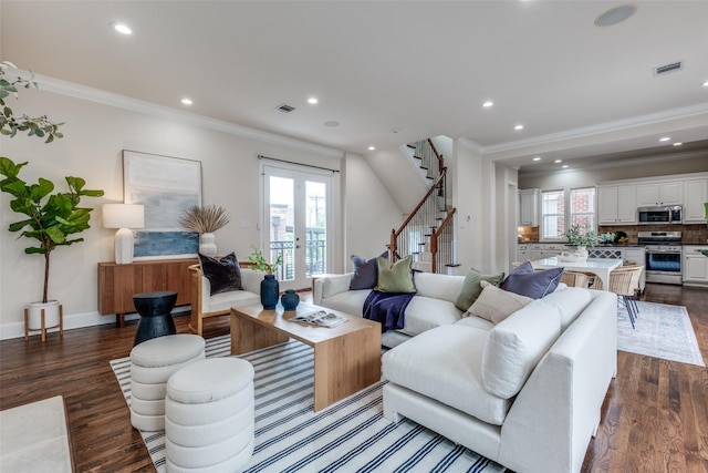 living area with crown molding, visible vents, dark wood finished floors, and stairway