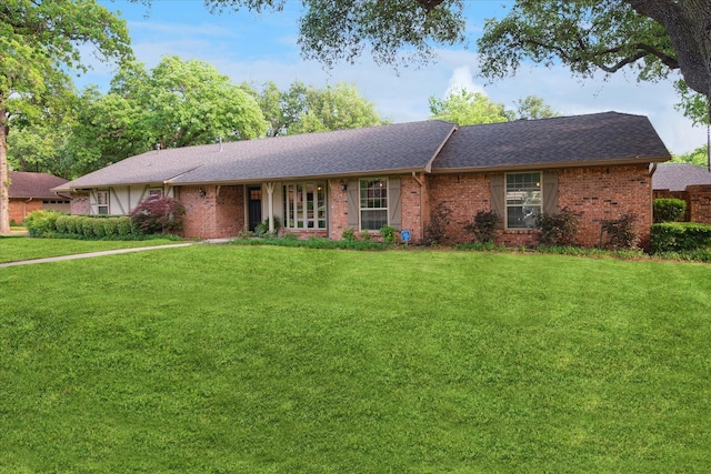ranch-style house with brick siding, a shingled roof, and a front yard