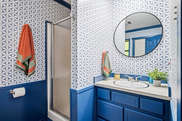 full bath featuring vanity, a stall shower, and wallpapered walls