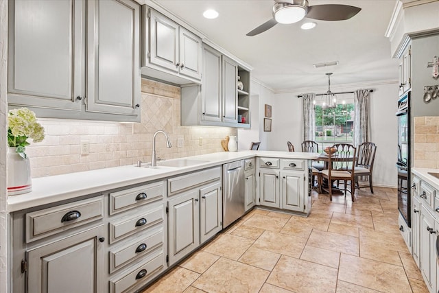 kitchen featuring decorative backsplash, dishwasher, a sink, light countertops, and ceiling fan with notable chandelier