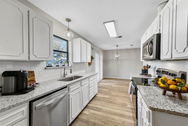 436 Fox Dr, Saginaw, TX 76179 - kitchen with light wood-style floors, baseboards, tasteful backsplash, a sink, and appliances with stainless steel finishes