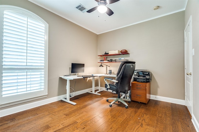 office space with ceiling fan, visible vents, crown molding, wood finished floors, and baseboards