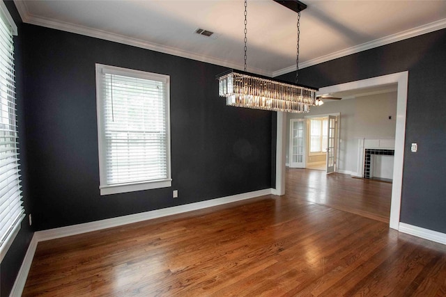 unfurnished dining area featuring visible vents, ornamental molding, wood finished floors, and a wealth of natural light