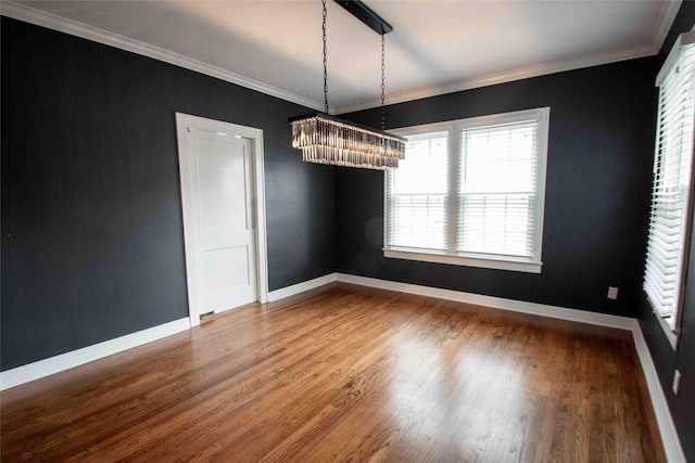 unfurnished dining area with baseboards, ornamental molding, and wood finished floors