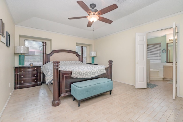 bedroom featuring connected bathroom, baseboards, multiple windows, and a tray ceiling