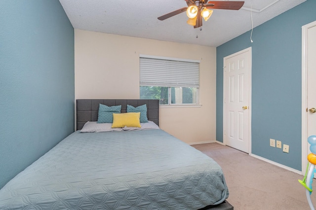 bedroom featuring a ceiling fan, baseboards, carpet, and attic access