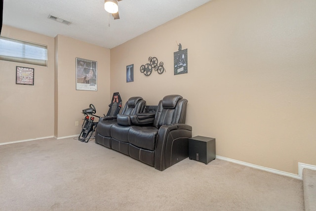 carpeted home theater featuring baseboards, a ceiling fan, and visible vents