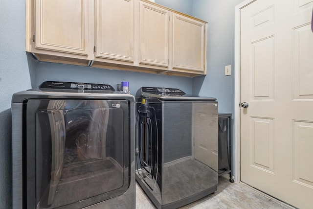 laundry area with washer and dryer, light wood finished floors, and cabinet space