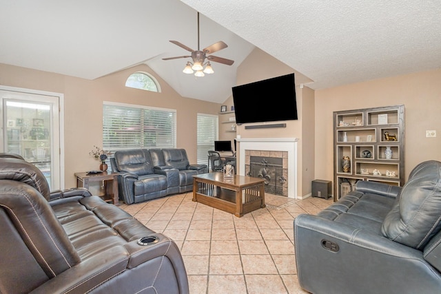 living room featuring light tile patterned flooring, ceiling fan, lofted ceiling, and a fireplace