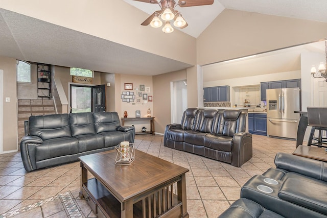 living room featuring light tile patterned floors, high vaulted ceiling, baseboards, and ceiling fan with notable chandelier