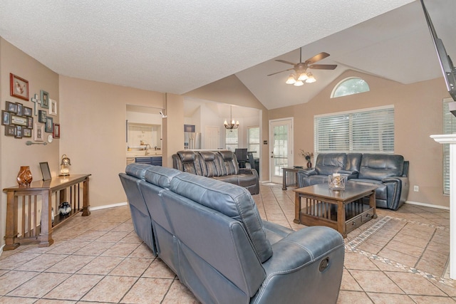 living room with baseboards, lofted ceiling, light tile patterned floors, and ceiling fan with notable chandelier