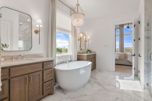 bathroom with marble finish floor, a shower stall, a sink, ensuite bath, and a notable chandelier