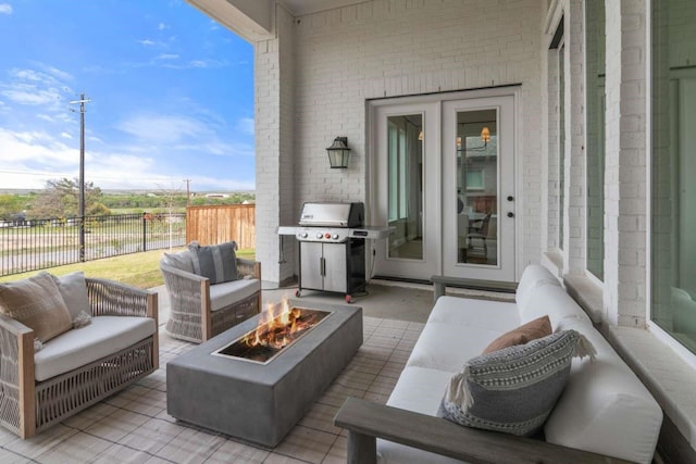 view of patio / terrace featuring an outdoor living space with a fire pit, fence, and grilling area