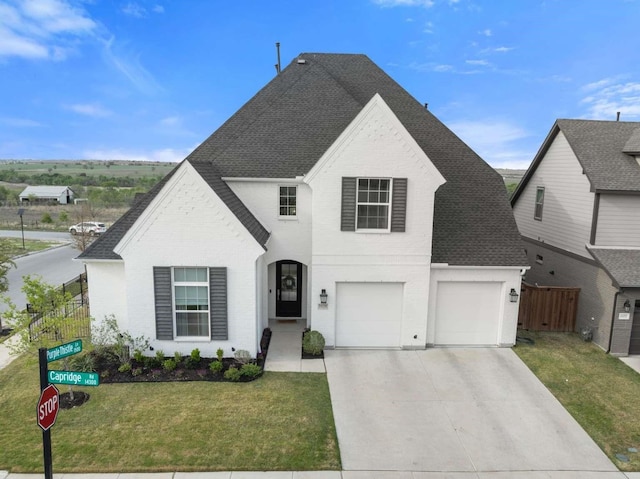 traditional-style house with fence, a shingled roof, an attached garage, and driveway