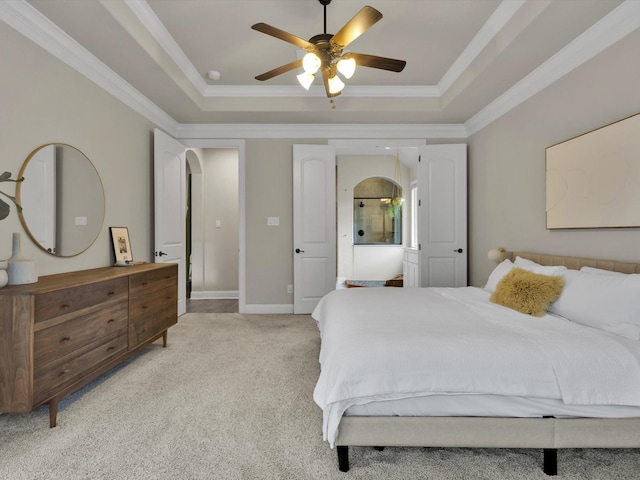 bedroom with light colored carpet, arched walkways, a raised ceiling, and crown molding