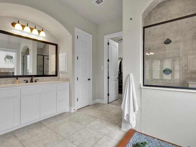 bathroom with vanity, tile patterned flooring, a closet, visible vents, and a tile shower
