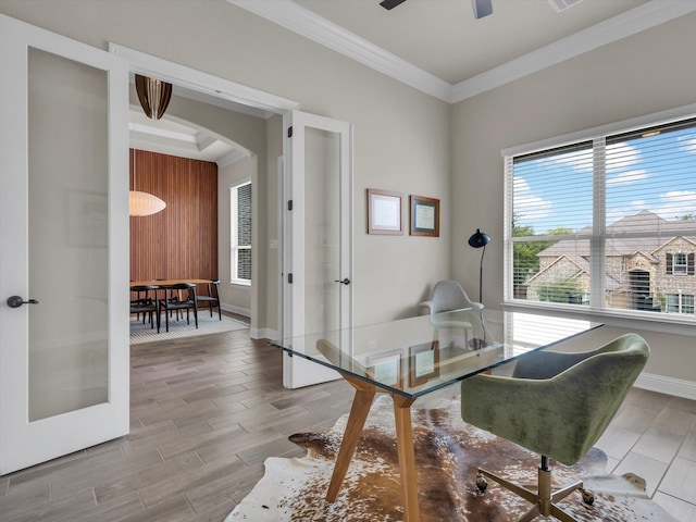 dining room with arched walkways, ornamental molding, french doors, and wood finish floors