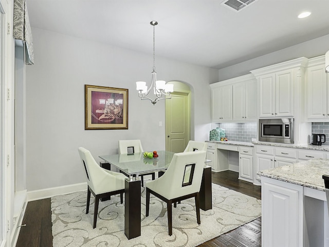 dining room with visible vents, an inviting chandelier, recessed lighting, arched walkways, and dark wood finished floors