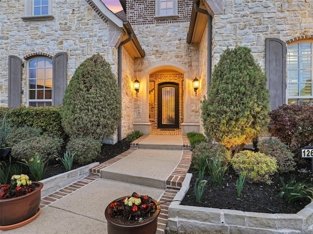 french country style house with brick siding, a front lawn, and stone siding