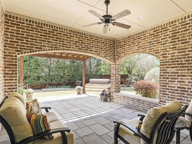 view of patio with a hot tub, ceiling fan, and a fenced backyard