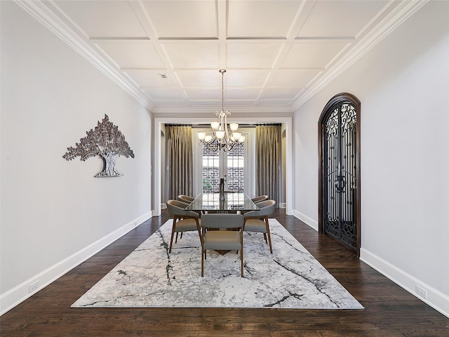 dining room with an inviting chandelier, crown molding, baseboards, coffered ceiling, and dark wood finished floors