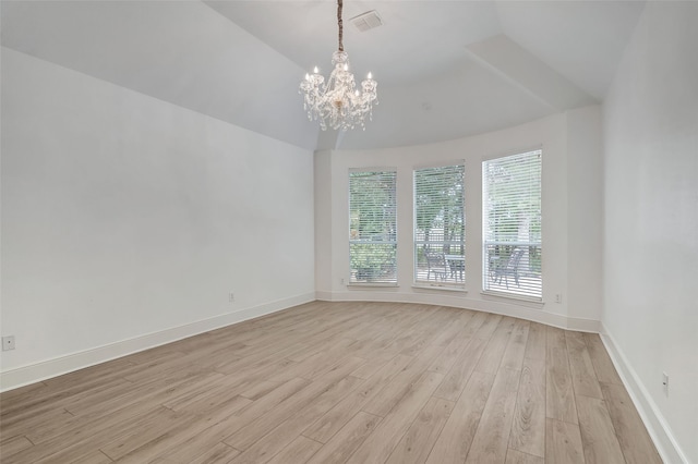 empty room featuring light wood-style floors, baseboards, a chandelier, and vaulted ceiling