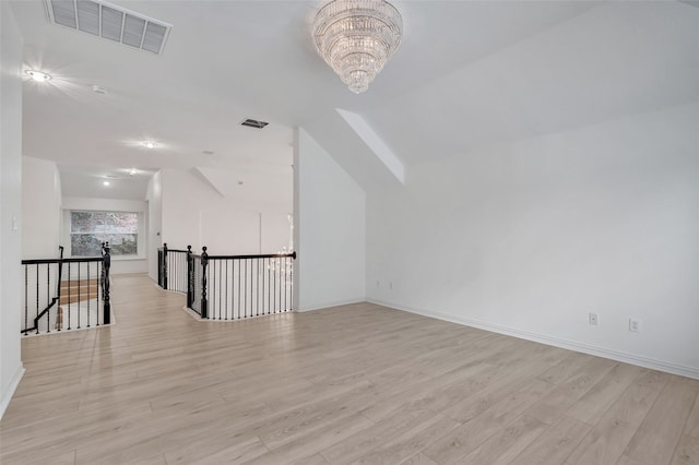 bonus room featuring visible vents, vaulted ceiling, baseboards, a notable chandelier, and light wood-style floors
