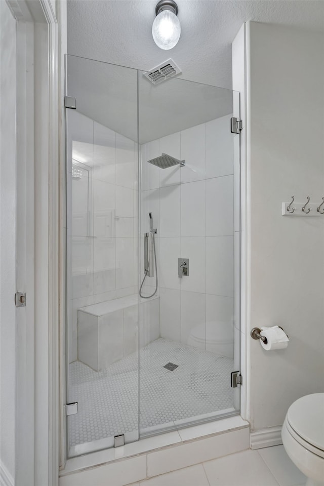 full bath featuring visible vents, toilet, baseboards, tile patterned floors, and a shower stall