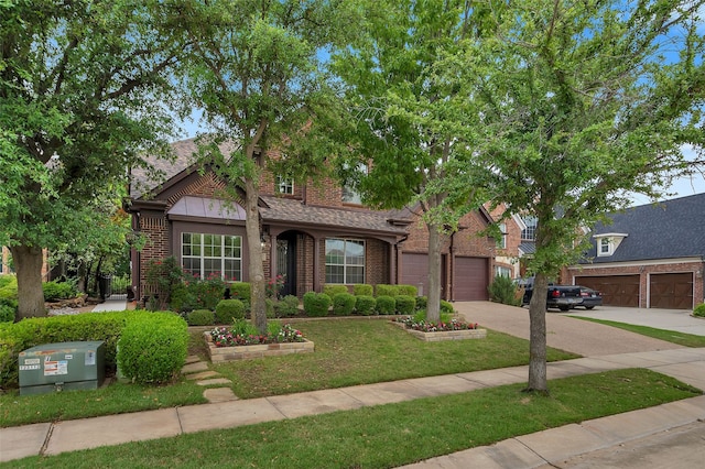 view of front of house featuring concrete driveway, brick siding, and a front yard