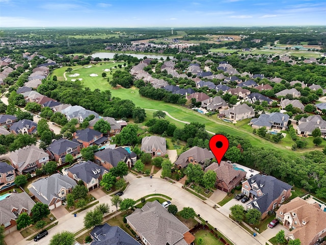 drone / aerial view featuring a water view, view of golf course, and a residential view