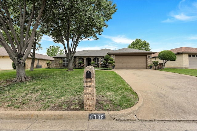 single story home featuring an attached garage, a front yard, and concrete driveway