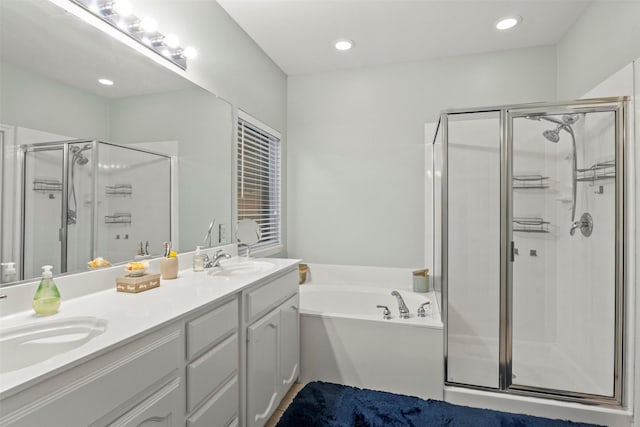 full bathroom with double vanity, a shower stall, a sink, and a garden tub