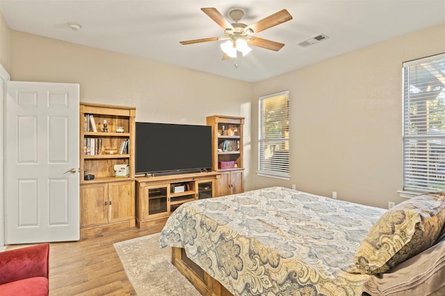 bedroom featuring a ceiling fan, visible vents, and light wood-style floors
