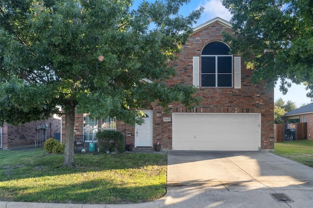 traditional-style house with an attached garage, a front lawn, brick siding, and concrete driveway