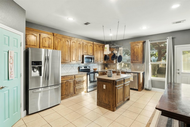 kitchen featuring visible vents, decorative backsplash, light countertops, light tile patterned floors, and stainless steel appliances