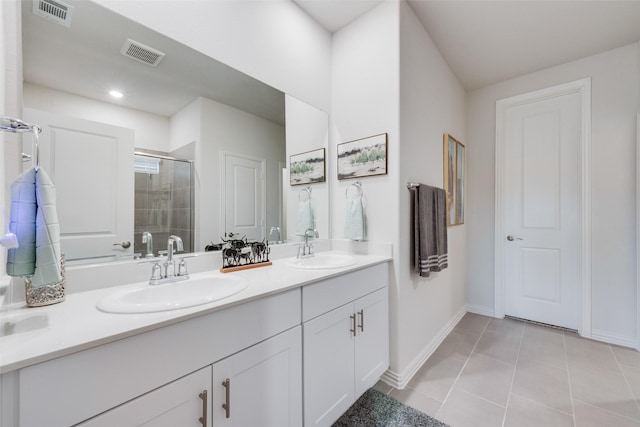 bathroom featuring visible vents, a sink, and a shower stall