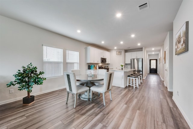 dining area with visible vents, recessed lighting, plenty of natural light, and light wood-type flooring