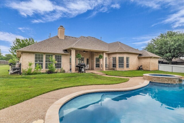 back of property featuring fence, a ceiling fan, an in ground hot tub, and brick siding