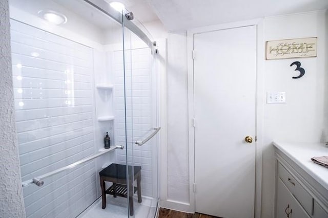 full bath featuring a shower stall, wood finished floors, and vanity