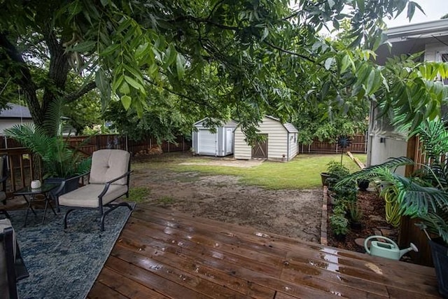 wooden terrace with a yard, an outbuilding, a fenced backyard, and a storage unit