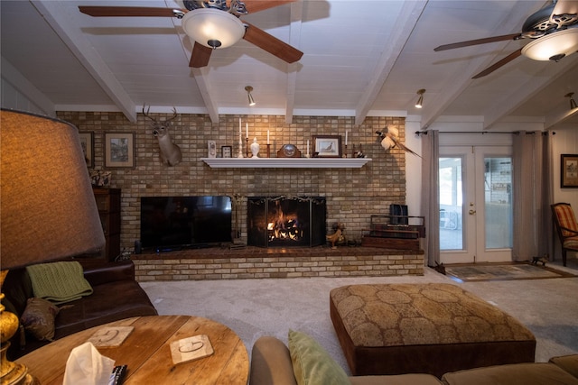 carpeted living room with french doors, a ceiling fan, a brick fireplace, and beamed ceiling