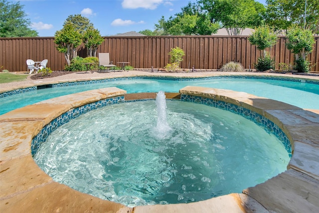 view of pool with a pool with connected hot tub and a fenced backyard