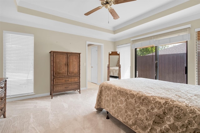 bedroom featuring baseboards, ornamental molding, a tray ceiling, and light carpet