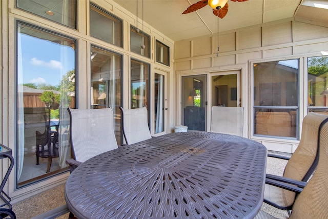 sunroom / solarium featuring ceiling fan and outdoor dining space