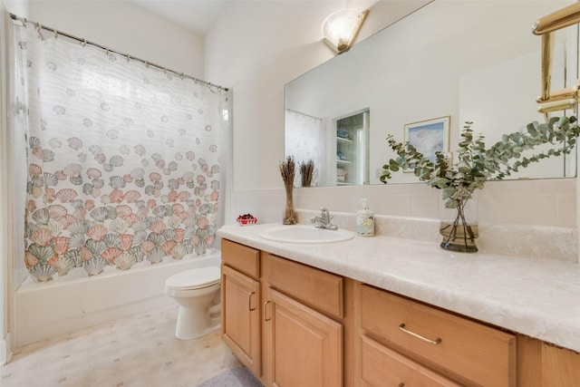 bathroom with decorative backsplash, toilet, shower / bath combination with curtain, and vanity