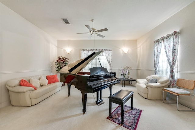 sitting room with carpet floors, ceiling fan, and visible vents