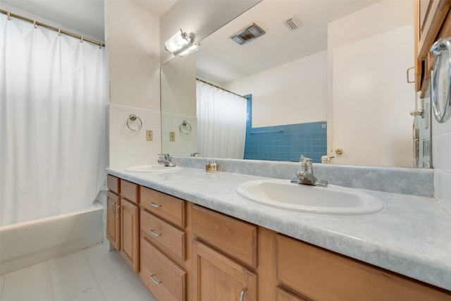 bathroom with double vanity, visible vents, a sink, and tile patterned flooring
